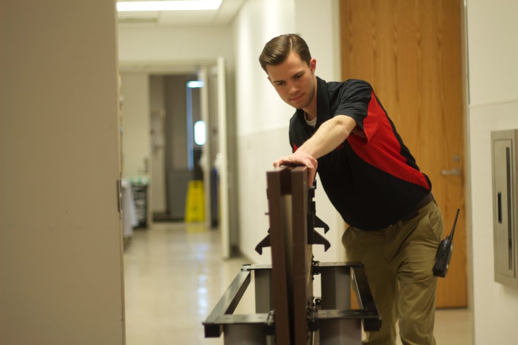 A student employee moves equipment for event setup at the student center.