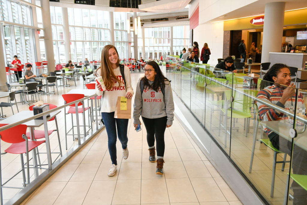 Two students walk through the Talley Pavillions dining area.